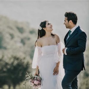 A joyful bride and groom share a loving glance in a beautiful outdoor setting.